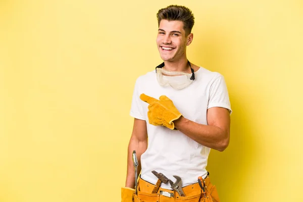 Joven Electricista Caucásico Aislado Sobre Fondo Amarillo Sonriendo Señalando Lado — Foto de Stock