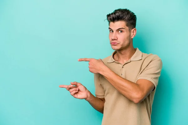 Young Caucasian Man Isolated Blue Background Shocked Pointing Index Fingers — Stock Photo, Image