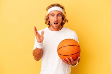 Young basketball player caucasian man isolated on yellow background surprised and shocked.