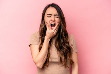 Pembe arka planda izole genç beyaz kadın güçlü bir diş ağrısı, azıdişi ağrısı var..