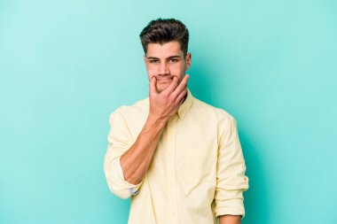 Kafkasyalı genç adam mavi arka planda izole edilmiş iki seçenek arasında şüphe duyuyor.