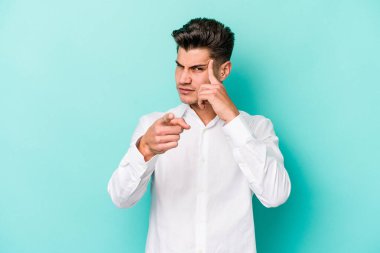 Mavi arka planda izole edilmiş genç beyaz bir adam şakağı parmağıyla işaret ediyor, düşünüyor ve bir göreve odaklanıyor..