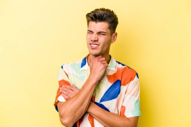 Sarı arka planda izole edilmiş genç beyaz bir adam virüs veya enfeksiyon yüzünden boğazında ağrı hissediyor..