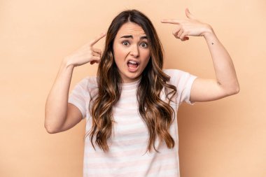 Beyazların arka planında izole edilmiş genç beyaz kadın işaret parmağıyla hayal kırıklığı jesti gösteriyor..