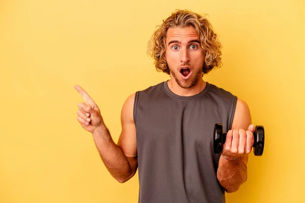 Young Sport Man Making Weightlifting Isolated Yellow Background Pointing Side — Stockfoto