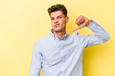 Sarı arka planda izole edilmiş, hoşlanmadığı bir hareket gösteren beyaz bir genç. Anlaşmazlık konsepti.