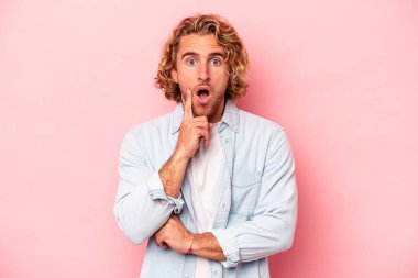 Pembe arka planda soyutlanmış genç beyaz bir adam. Harika bir fikri var, yaratıcılık kavramı..