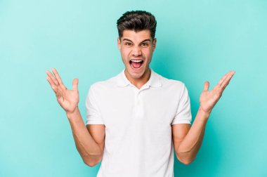 Kafkasyalı genç adam mavi arka planda izole edilmiş gökyüzüne haykırıyor, yukarı bakıyor, hayal kırıklığına uğramış..