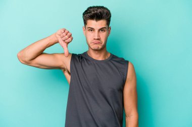 Mavi arka planda izole edilmiş genç beyaz bir adam hoşlanmadığı bir jest yapıyor. Anlaşmazlık konsepti.