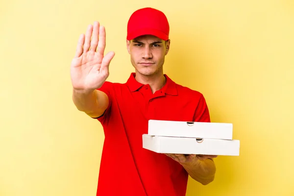 Young Delivery Caucasian Man Holding Pizzas Isolated Yellow Background Standing — ストック写真