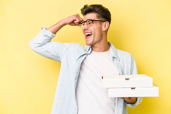 Joven Caucásico Sosteniendo Pizzas Aisladas Sobre Fondo Amarillo Levantando Puño — Foto de Stock