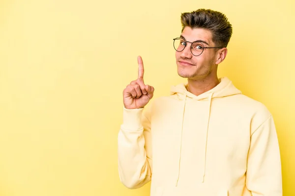 Νεαρός Καυκάσιος Άνδρας Απομονωμένος Κίτρινο Φόντο Δείχνει Νούμερο Ένα Δάχτυλο — Φωτογραφία Αρχείου