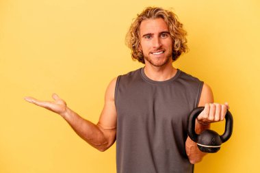 Sarı arka planda halter yapan genç sporcu bir avuç içinin fotokopi çektiğini ve belinde bir el daha tuttuğunu gösteriyor..