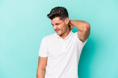 Kafkasyalı genç bir adam mavi arka planda izole edilmiş. Durağan yaşam tarzından dolayı boyun ağrısı çekiyor..