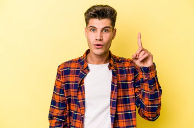 Sarı arka planda izole edilmiş beyaz bir adam ağzı açık bir şekilde üst tarafı işaret ediyor..