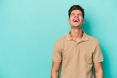 Kafkasyalı genç adam mavi arka planda izole edilmiş. Çok kızgın, öfkeli, hayal kırıklığına uğramış..