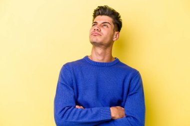 Sarı arka planda izole edilmiş genç beyaz adam tekrarlanan bir görevden bıktı..