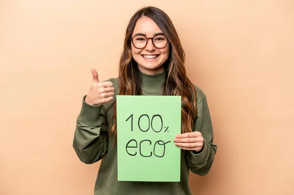 Młoda Kaukaska Kobieta Trzymająca 100 Eko Tabliczkę Beżowym Tle Uśmiechnięta — Zdjęcie stockowe