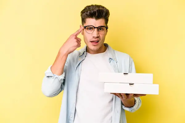 Joven Hombre Caucásico Sosteniendo Pizzas Aisladas Sobre Fondo Amarillo Mostrando — Foto de Stock