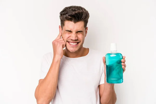 Young Caucasian Man Holding Mouthwash Isolated White Background Covering Ears — Foto Stock