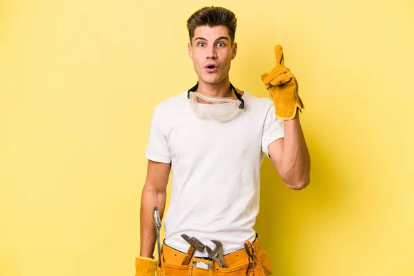 Jovem Eletricista Caucasiano Homem Isolado Fundo Amarelo Tendo Alguma Grande — Fotografia de Stock