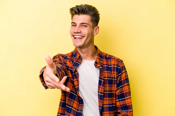 Jonge Blanke Man Geïsoleerd Gele Achtergrond Stretching Hand Camera Groet — Stockfoto