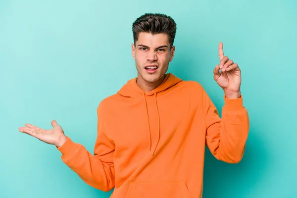 Jovem Caucasiano Isolado Fundo Azul Segurando Mostrando Produto Mão — Fotografia de Stock