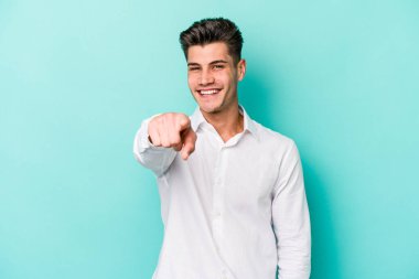 Mavi arka planda izole edilmiş genç beyaz adam öne bakan neşeli gülümsemeler.