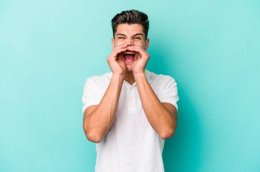 Mavi arka planda izole edilmiş beyaz bir adam heyecanlı bir şekilde bağırıyor..