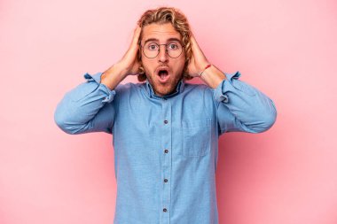 Pembe arka planda izole edilmiş genç beyaz adam şok geçiriyordu, önemli bir buluşmayı hatırladı..