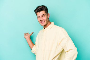 Mavi arka planda izole edilmiş beyaz bir genç hoş bir yüz ifadesi sergiliyor..