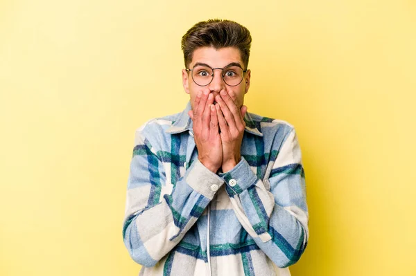 Joven Hombre Caucásico Aislado Sobre Fondo Amarillo Impactado Cubriendo Boca —  Fotos de Stock