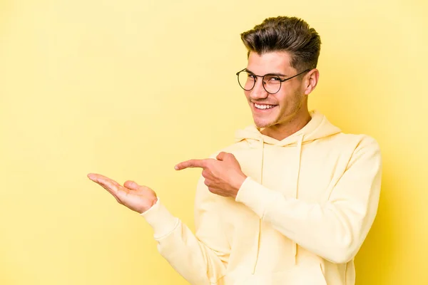 Νεαρός Καυκάσιος Άνδρας Απομονωμένος Κίτρινο Φόντο Ενθουσιασμένος Κρατώντας Ένα Χώρο — Φωτογραφία Αρχείου