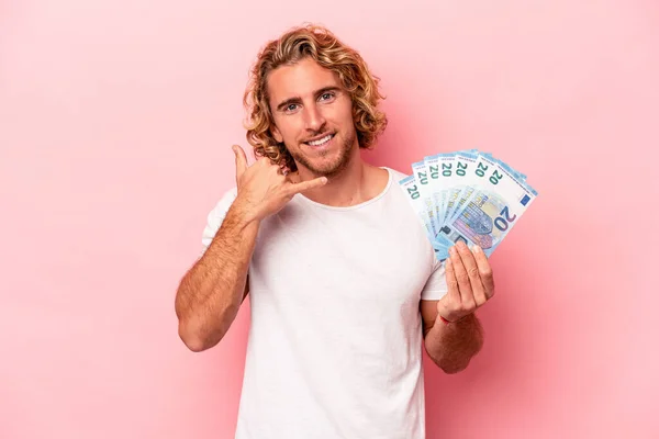 Young Caucasian Man Holding Banknotes Isolated Pink Background Showing Mobile — Stockfoto