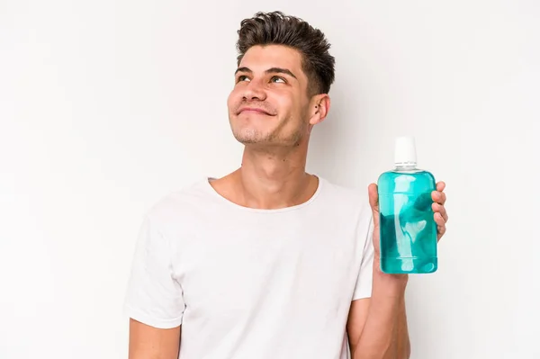 Young Caucasian Man Holding Mouthwash Isolated White Background Dreaming Achieving — Stockfoto