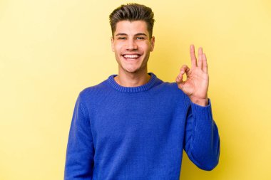Genç beyaz adam sarı arka planda izole edilmiş neşeli ve kendinden emin..