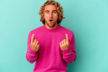 Mavi arka planda izole edilmiş beyaz bir adam ağzı açık bir şekilde üst tarafı işaret ediyor..