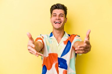 Sarı arka planda izole edilmiş beyaz bir genç hoş bir yüz ifadesi sergiliyor..