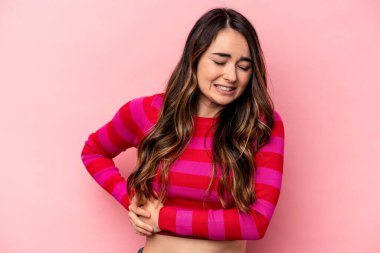 Pembe arka planda karaciğer ağrısı çeken, karnı ağrıyan beyaz bir kadın..