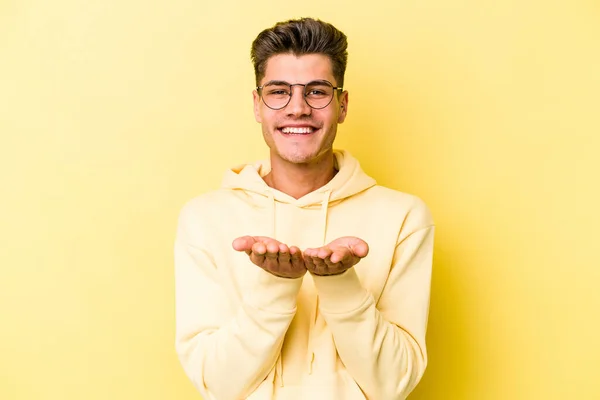 Jonge Blanke Man Geïsoleerd Gele Achtergrond Met Iets Met Handpalmen — Stockfoto