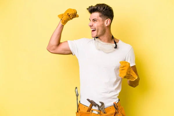 Young Electrician Caucasian Man Isolated Yellow Background Raising Fist Victory — Stock Fotó