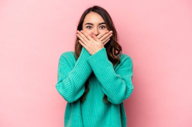 Pembe arka planda izole edilmiş beyaz bir kadın elleriyle ağzını kapatırken şok oldu..