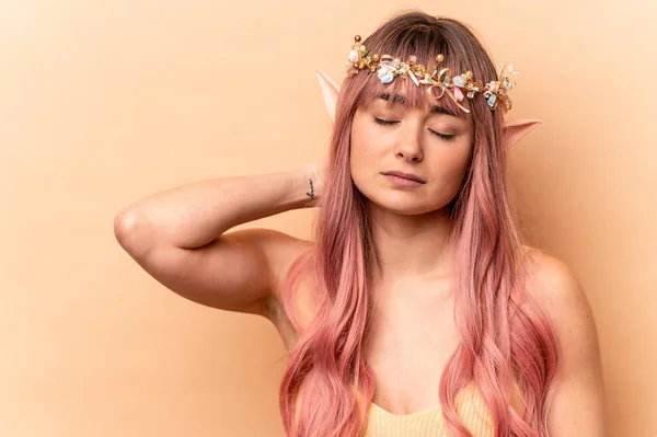 Young elf woman with pink hair isolated on beige background touching back of head, thinking and making a choice.