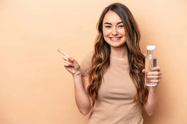 Ung Kaukasisk Kvinna Håller Flaska Vatten Isolerad Beige Bakgrund Ler — Stockfoto