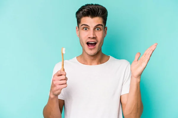 Young Caucasian Man Brushing Teeth Isolated White Background Surprised Shocked — Stockfoto