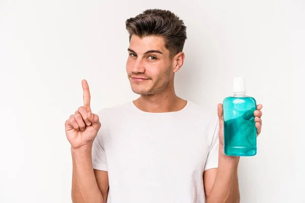 Young Caucasian Man Holding Mouthwash Isolated White Background Showing Number — Stock fotografie