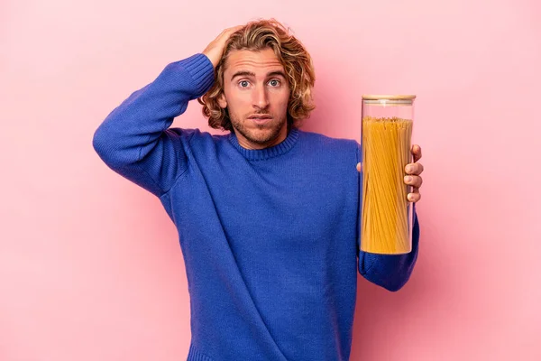 Young Caucasian Man Holding Spaghettis Jar Isolated Pink Background Being — Stock Photo, Image