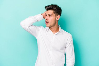 Mavi arka planda izole genç beyaz adam şok oldu, o önemli bir toplantı hatırladı.