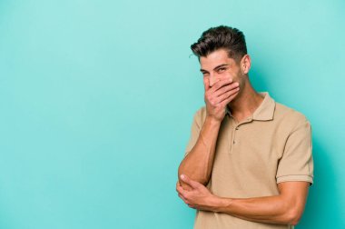 Kafkasyalı genç adam mavi arka planda yalnızdı gülerek, kaygısızca, doğal duygularla.