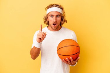 Young basketball player caucasian man isolated on yellow background having an idea, inspiration concept.
